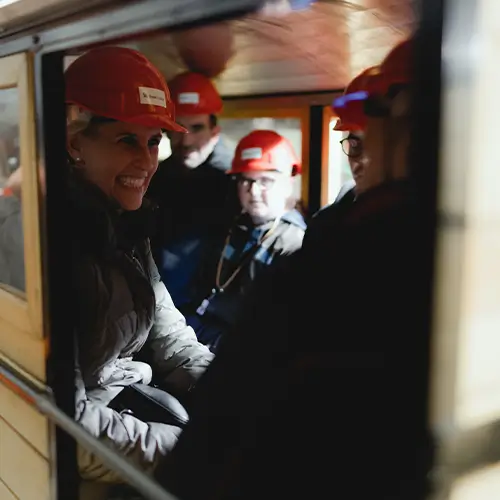 frau_lachend Eine Frau und andere Leute sitzen lachend zusammen in einem Bergbauwagen-Abteil.